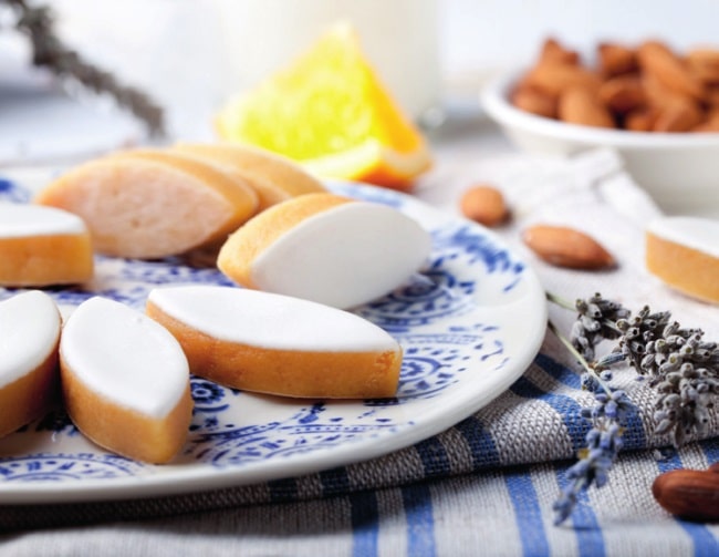 Almond-shaped slices of candied fruit paste, topped with royal icing