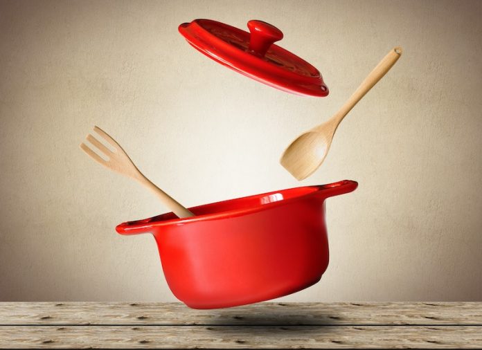 big red pot with wooden spoon and fork