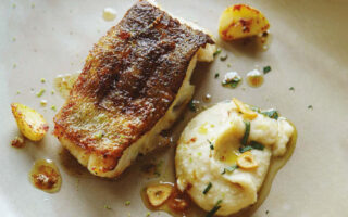 Pan fried cod loin with white bean purée & garlic crisps